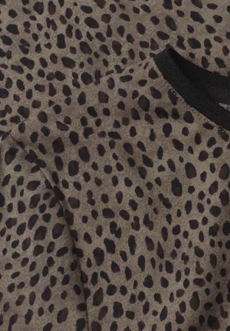 Nahaufnahme eines beige-braunen Stoffs mit schwarzem Leopardenmuster und schwarzem Kragen.