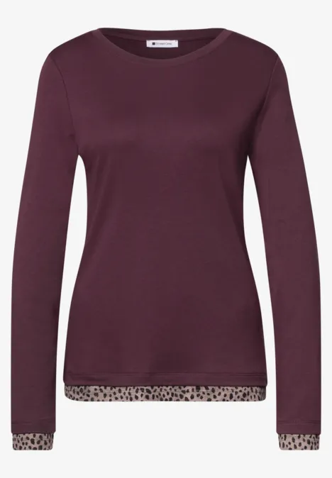 Lila Damenpullover mit langen Ärmeln und dezenten Leopardmusterabschlüssen an Saum und Manschetten.