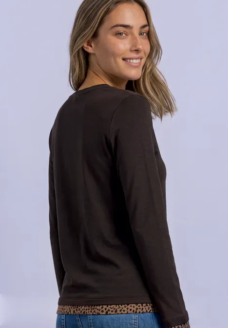 Langarm Shirt mit Colorblock und Printdetail black coffee Junge Frau im schwarzen Langarmshirt mit dezentem Leopardenmuster am Saum, schaut lächelnd über die Schulter.
