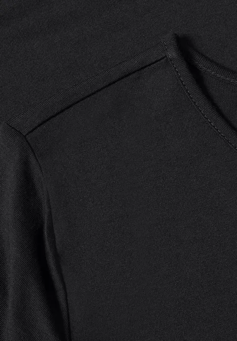 Langarm Shirt mit Rundhals und Spitze Black Nahaufnahme eines schwarzen T-Shirts mit sichtbarer Naht am Schulterbereich.