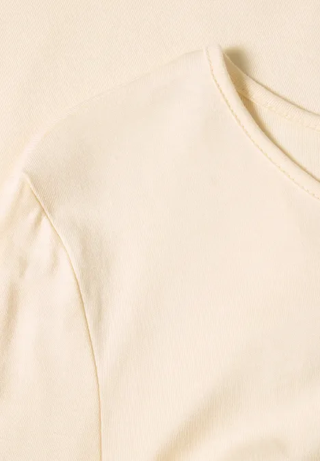 Ein schlichtes, hellbeiges T-Shirt mit Rundhalsausschnitt auf hellem Hintergrund.