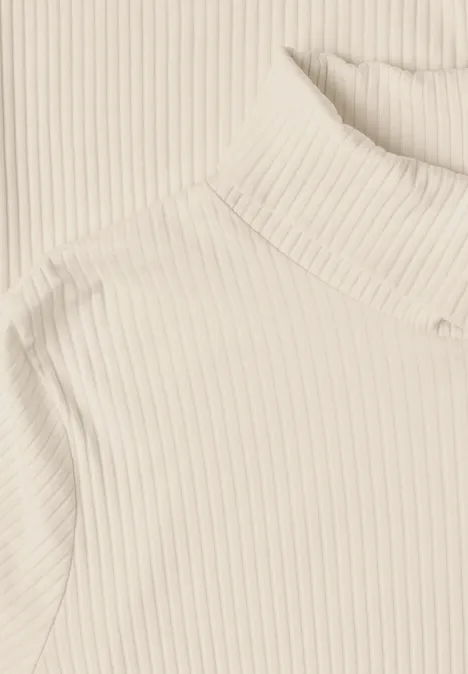 T-shirt basique uni à col roulé pure beige Pull à col roulé beige à côtes fines sur fond clair.