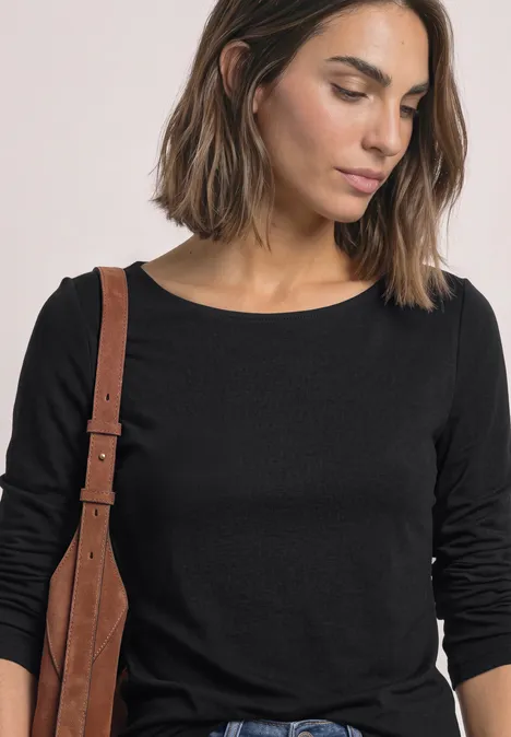 T-shirt basique à col bateau Black Eine Frau mit brauner Schultertasche trägt ein schlichtes schwarzes Langarmshirt.