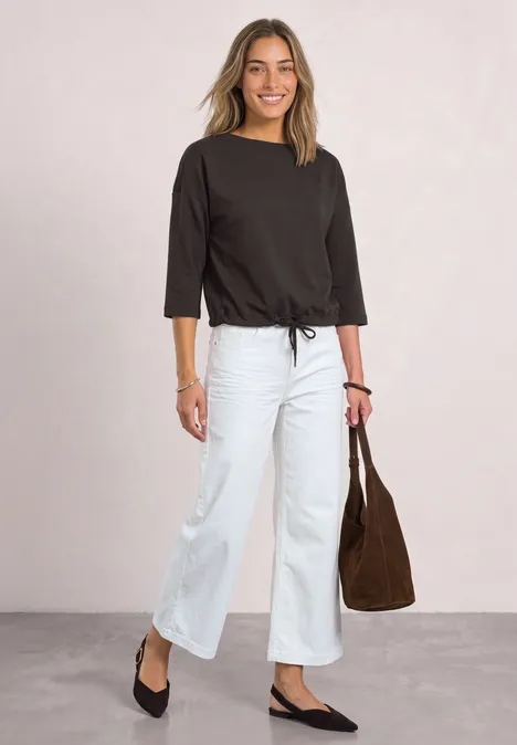 3/4-Arm Shirt mit Boat Neck und Tunnelzug black coffee Frau in schwarzem 3/4-Ärmel-Shirt, weißen weiten Jeans und schwarzen Ballerinas, trägt braune Tasche.