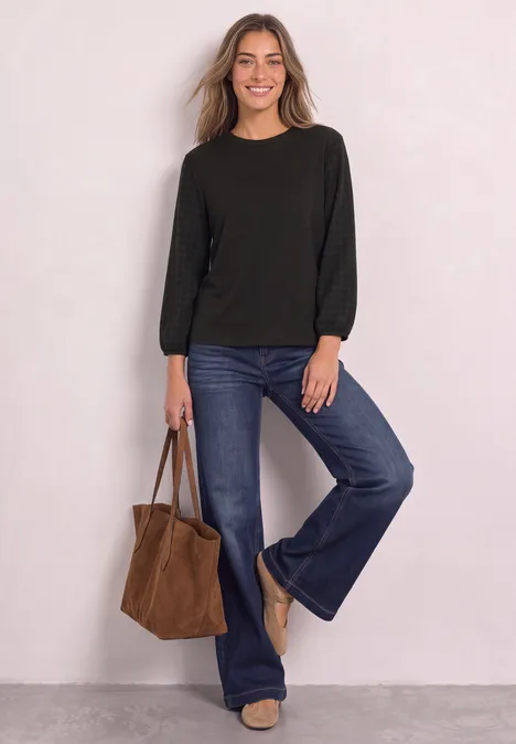 Shirt mit Rundhals und Strukturärmeln black coffee Frau lächelt, trägt schwarzen Pullover, Schlagjeans und hält eine braune Tasche.