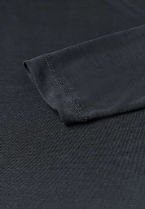 Close-up van de zwarte mouw van een T-shirt liggend op een witte achtergrond.