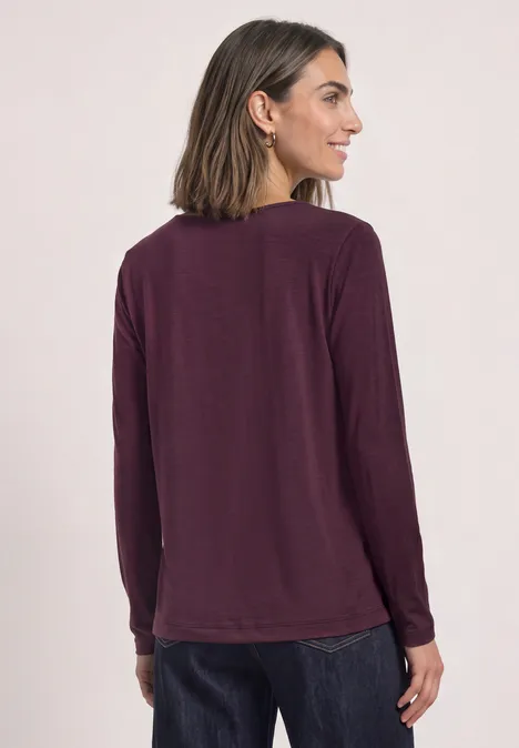Dames top aubergine met lange mouwen, achterkant zichtbaar.