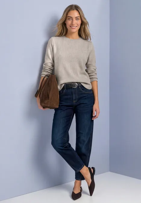 Langarm Shirt mit seitlichen Knopfdetails sanded amber mel. Eine Frau trägt einen Pullover, dunkle Jeans, schwarze Ballerinas und hält eine Tasche.