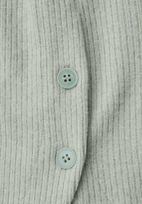Langarm Shirt mit seitlichen Knopfdetails eucalyptus green mel. Detailansicht eines hellgrünen, gerippten Strickoberteils mit zwei Knöpfen