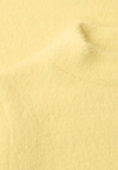 Sanfter, gelber Rollkragenpullover aus weichem, flauschigem Stoff.