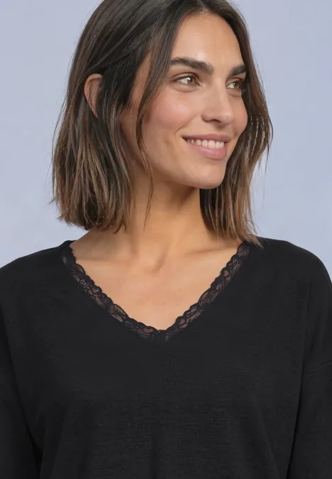 T-shirt à manches longues, col en V et détail en dentelle Black Eine lächelnde Frau mit schulterlangem braunem Haar und einem schwarzen Spitzen-V-Shirt.