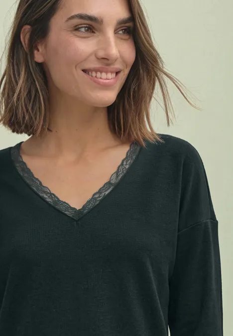 T-shirt à manches longues, col en V et détail en dentelle stormy green Eine lächelnde Frau in schwarzem V-Ausschnitt-Oberteil mit Spitzenbesatz.
