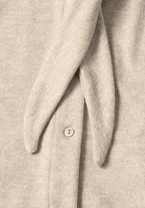 Beige Strickjacke mit Knopf und zwei spitz zulaufenden Zipfeln.