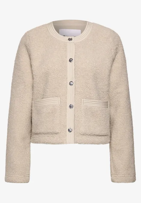Cremefarbener Teddy-Fleece-Cardigan mit Knopfleiste und zwei aufgesetzten Taschen im legeren Cropped-Schnitt.