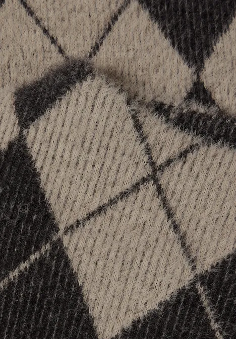 Close-up van een gebreide stof met zwart-beige ruitmotief.