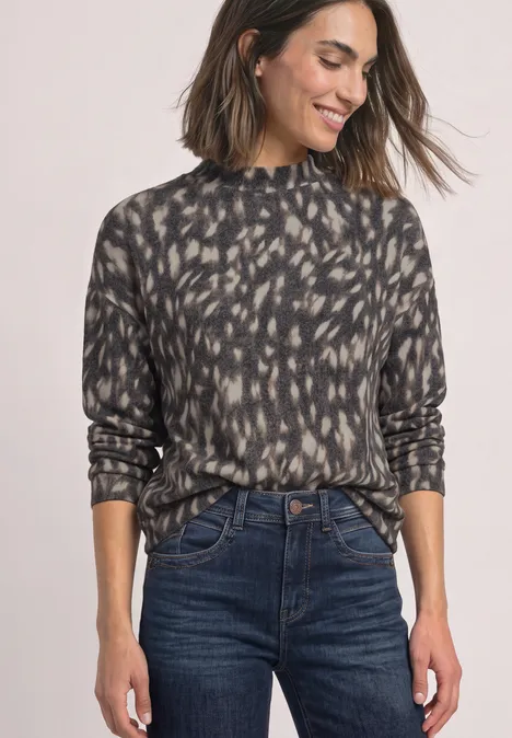 Shirt met lange mouwen, col en patroon Black Donkergrijze coltrui met abstracte print, gecombineerd met een high-waist donkere spijkerbroek.