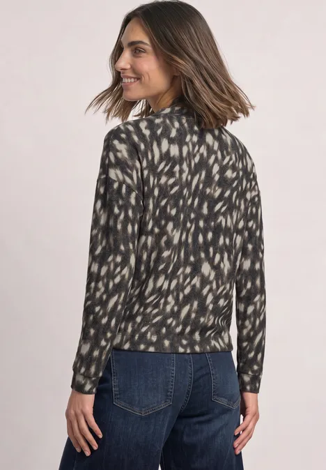 Shirt met lange mouwen, col en patroon Black Vrouw in een zwart-beige blouse met patroon, van achteren, draait hoofd opzij en lacht.