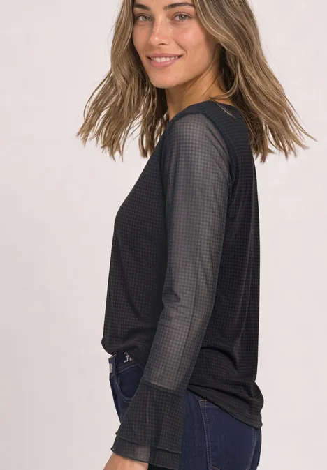 Shirt aus Mesh mit langen Volant-Ärmeln black coffee Junge Frau im schwarzen Mesh-Oberteil und Jeans, seitlich stehend und lächelnd.