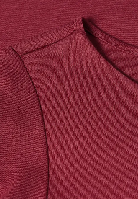 Close-up van een mouwloos bordeaux shirt van zacht jersey.