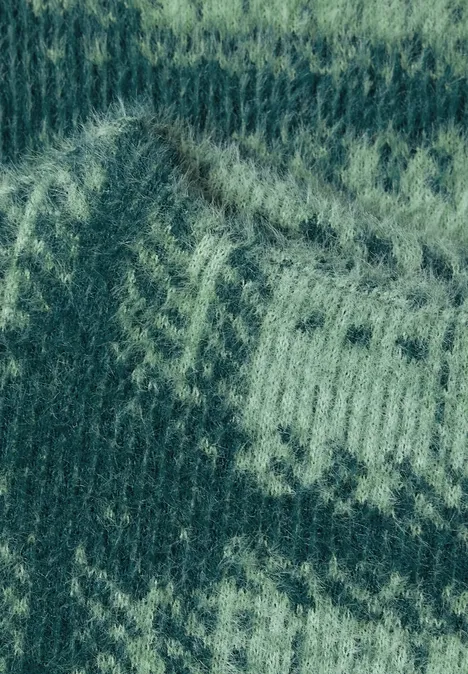 Groen gebreid patroon met lichtere zigzag-ornamenten, Fair Isle-stijl.