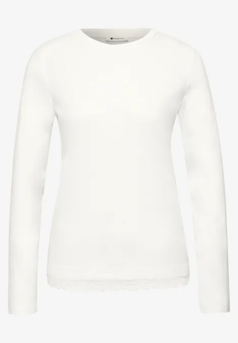 T-shirt à manches longues, col rond et bordure en dentelle off white Weißes Langarmshirt mit Rundhalsausschnitt und Spitzenbesatz am Saum.