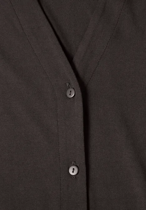 Nahaufnahme eines dunkelbraunen Cardigans mit Knöpfen.