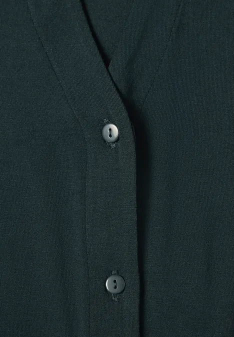 Close-up van een donker vest met V-hals en knoopsluiting