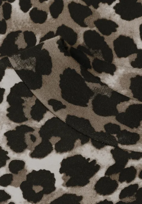 Naheinstellung eines beigen Stoffstücks mit markantem schwarzen Leopardenmuster.