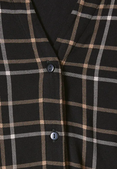 Tissu noir à motifs à carreaux beige avec deux boutons discrets.
