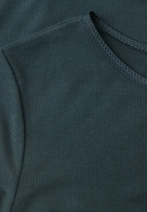 Close-up van een donkergroene, fijngeribbelde T-shirt met ronde hals.
