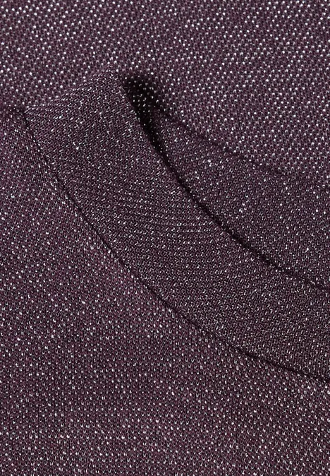 Gros plan sur un tissu tricot bordeaux avec une poche discrète