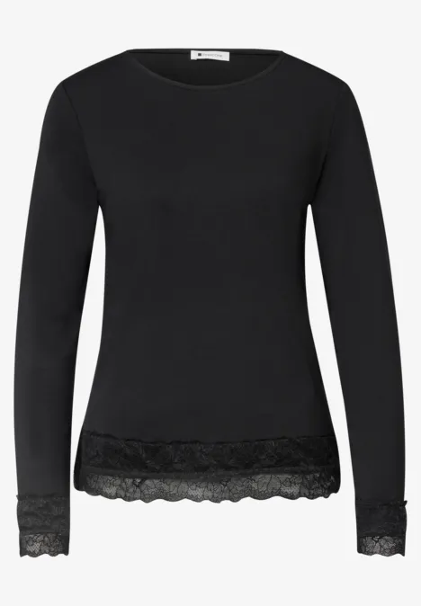 Schwarzes Langarmshirt mit Spitzenbesatz am Saum und an den Ärmelenden.