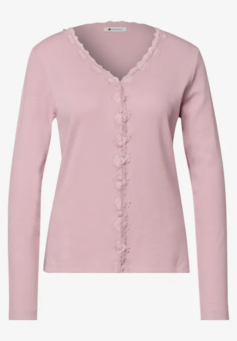 Veste à fines côtes, col en V et dentelle quiet rose Zartrosa Damenstrickjacke mit V-Ausschnitt, langen Ärmeln und verspielter Spitzenborte am Kragen und der Knopfleiste.
