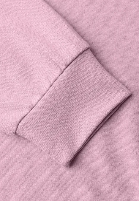 T-shirt en maille à manches chauve-souris quiet rose Nahaufnahme eines rosa Sweatshirt-Ärmels mit elastischem Bündchen.