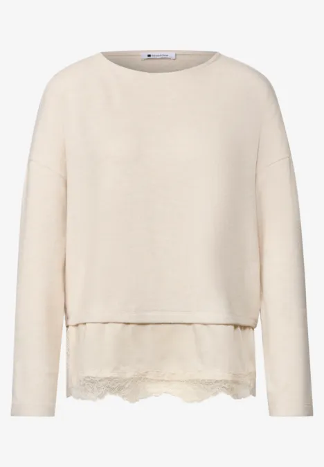 Cremefarbener, langärmeliger Pullover mit Rundhalsausschnitt und zarter Spitzenblende am Saum.