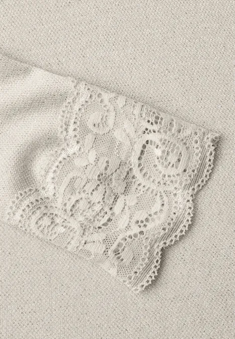 T-shirt à manches longues avec paillettes et dentelle pure beige Nahaufnahme eines beigen Spitzenstoffs mit aufwendiger Spitzenbordüre.