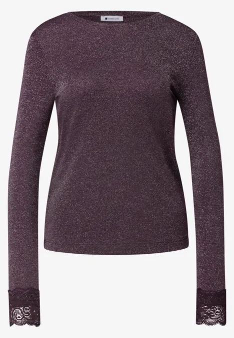 Lila schimmerndes Langarmshirt aus Glitzerstoff mit Spitzenbesatz an den Ärmelenden