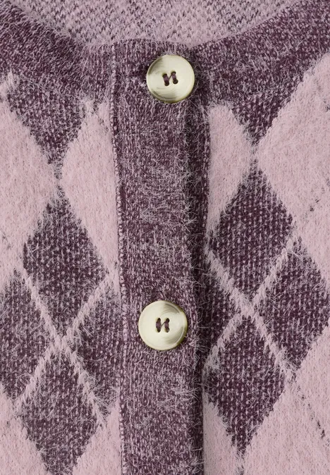 Nahaufnahme eines rosa-violetten Strickcardigans mit Rautenmuster und zwei Perlmuttknöpfen.