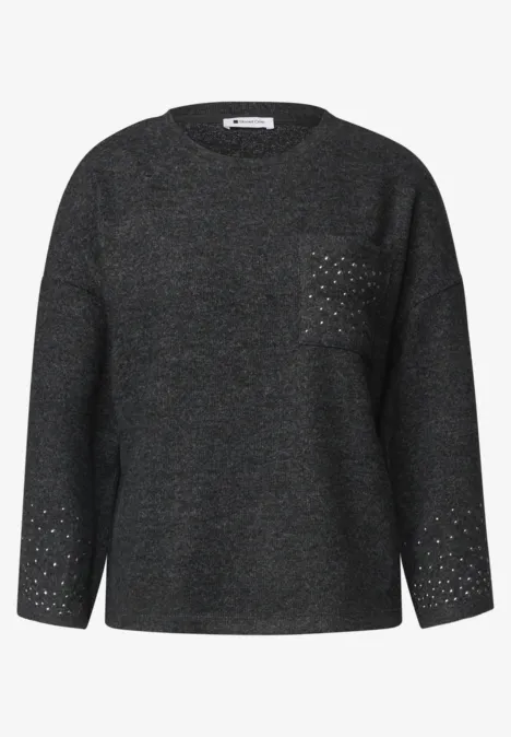 Grauer Oversize-Pullover mit Rundhalsausschnitt, Brusttasche und feinem Lochmuster an Ärmelabschlüssen.