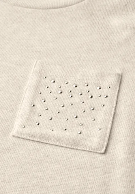 Beiges Shirt mit aufgesetzter Tasche, dekoriert mit gleichmäßig verteilten kleinen Perlen.