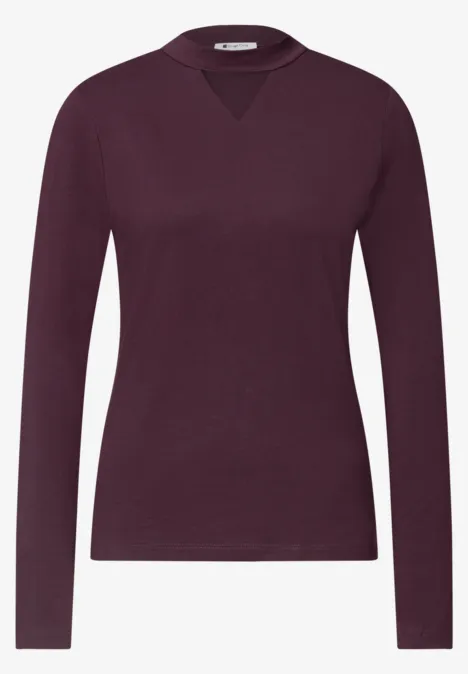 Ein schlichtes, langärmliges Damen-Shirt in dunklem Beerenton mit dezentem V-Einsatz am Rundhalsausschnitt.