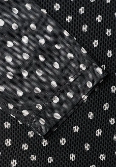 Schwarzer Stoff mit weißen Polka Dots und Naht, Detailansicht.
