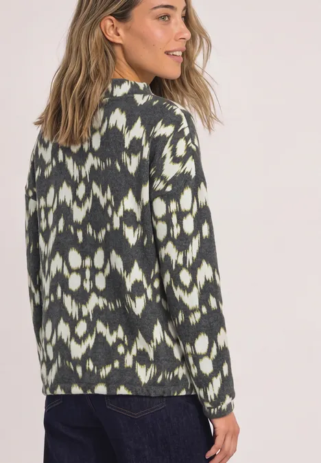 T-shirt à manches longues, col roulé et imprimé Black Eine Frau trägt einen Pullover mit grün-weißem Ikat-Muster und schaut über die Schulter.