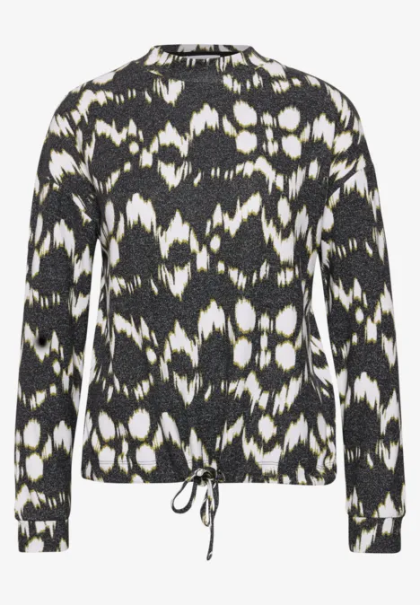 Langärmliger Pullover mit schwarz-weißem abstraktem Muster und Kordelzug am Saum.