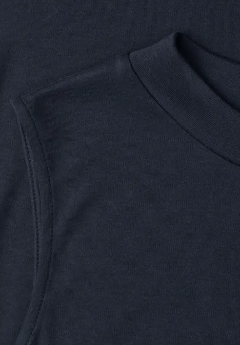 Zbliżenie granatowego t-shirtu z okrągłym dekoltem i starannie wykończonym szwem rękawa.