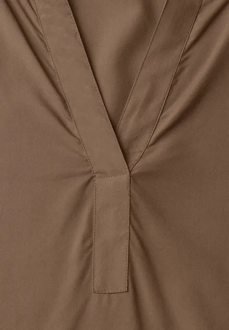 Tuniek met V-hals sanded amber Braunes Kleidungsstück mit V-förmigem Ausschnitt und mittiger Steppnaht.