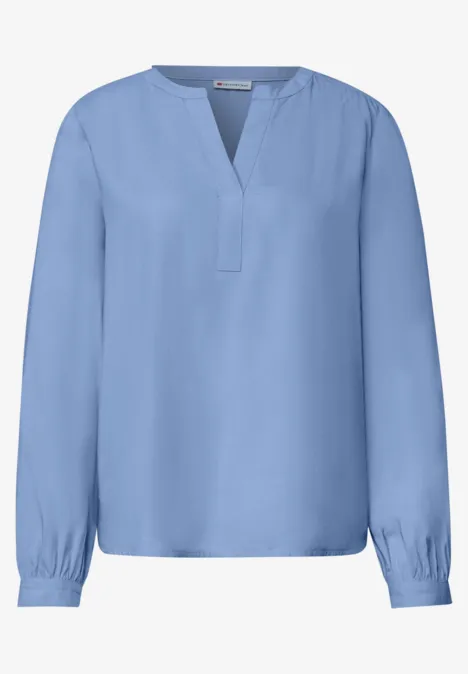 Lichtblauwe damesblouse met V-hals en lange mouwen.