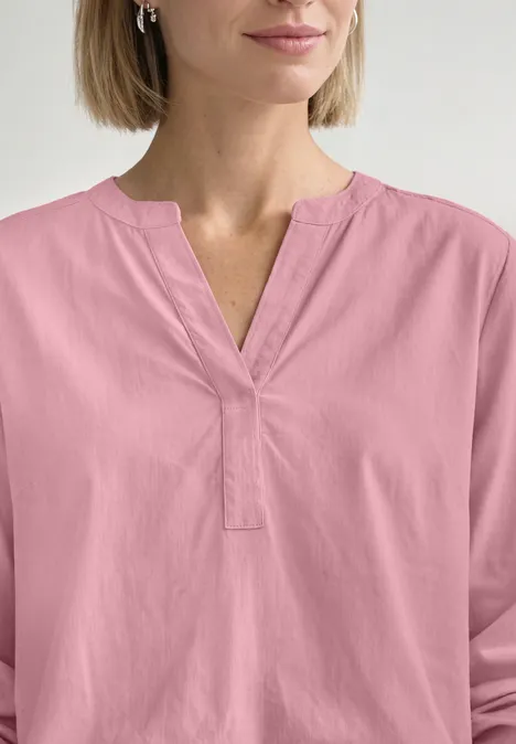 Tuniek met V-hals vintage blush Frau trägt eine rosafarbene, lockere Bluse mit V-Ausschnitt und langen Ärmeln.