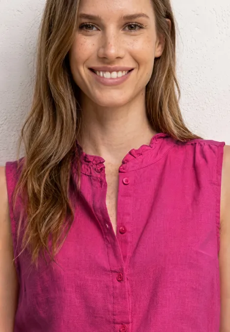 Frau trägt pinkfarbene ärmellose Bluse mit Knopfleiste