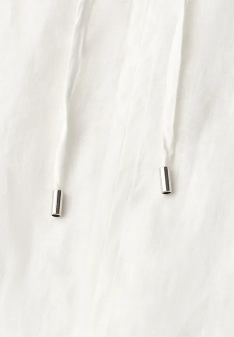 Witte koord met zilverkleurige uiteinden op licht stof.